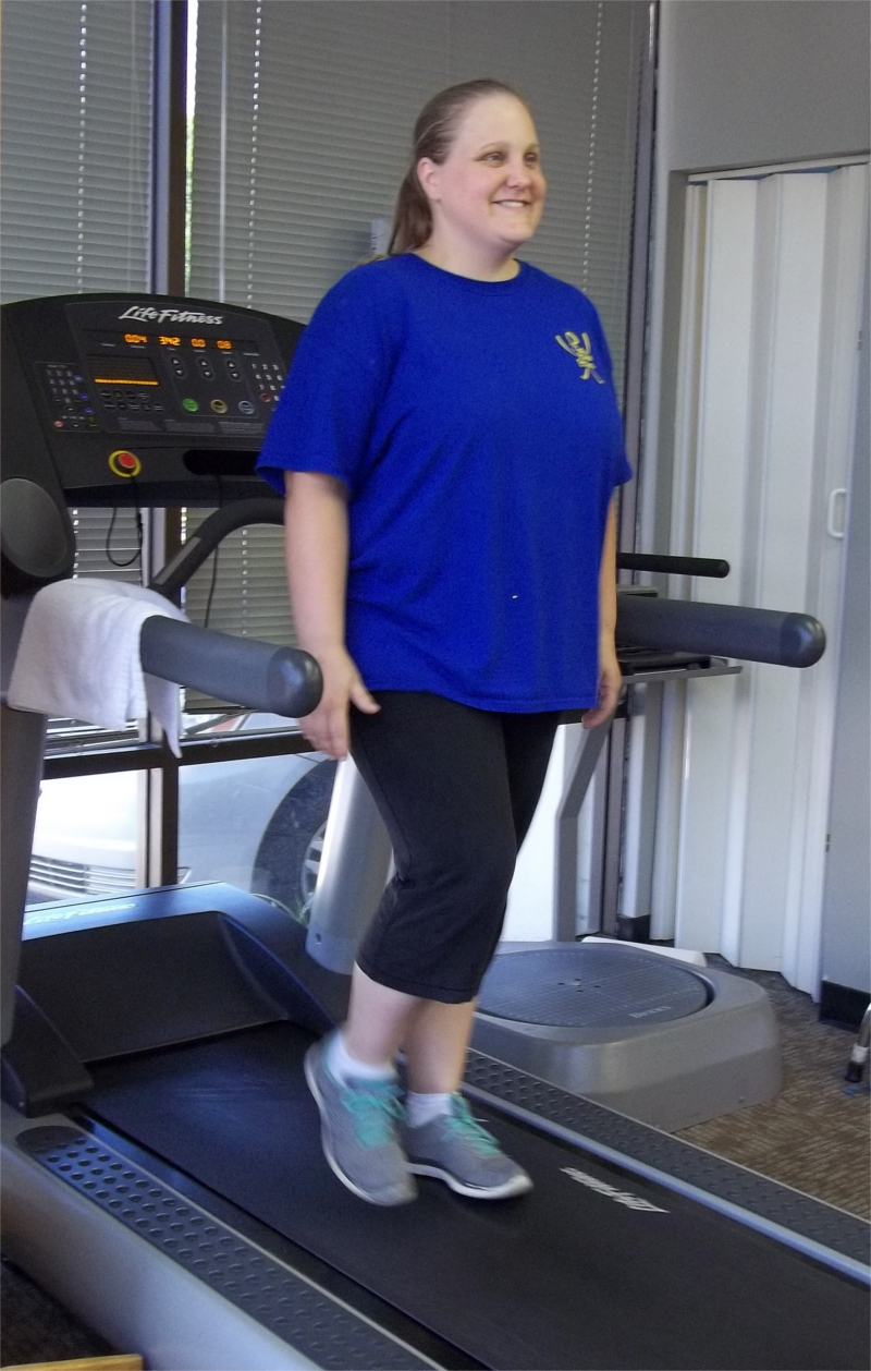 Woman Smiling while Walking Backwards on Treadmill